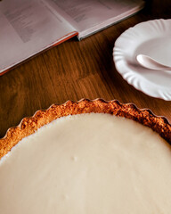Autumn recipes concept. Composition with a homemade autumn pie, a dessert plate and a cookbook  on wooden background. Autumn, fall mock up. Detail close-up, earth tones.