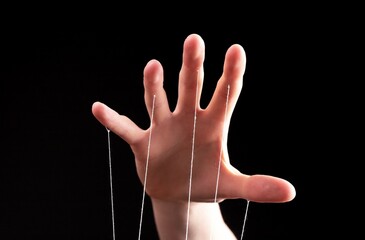 Manipulation, authority concept. Hand with strings controlling, manipulating smth abstract