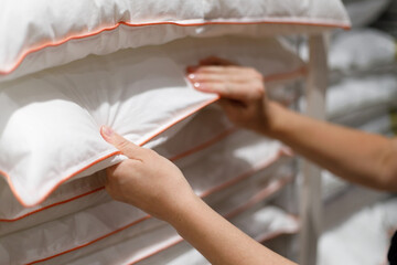 The customer's hands hold a pillow in the store. Sale.
