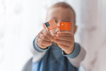 Kid showing Usa and china national flag. Symbol of relationships of United States of America and Republic of China