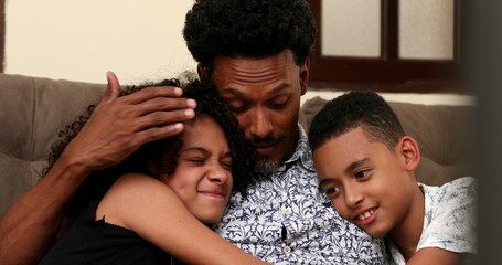 Candid parent embracing son and daughter, brazilian African descent