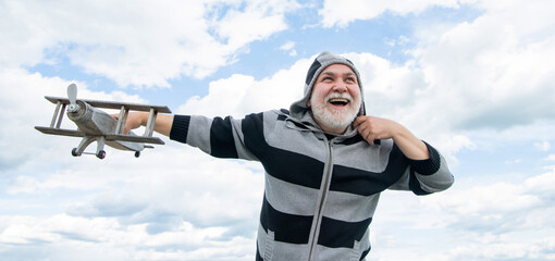 mature senior man on sky background. senior man at retirement. senior retired man with toy plane