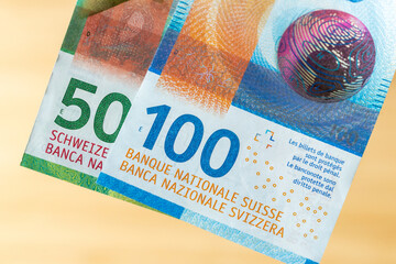 Banknotes of one hundred and fifty Swiss francs on a light wooden background, financial concept