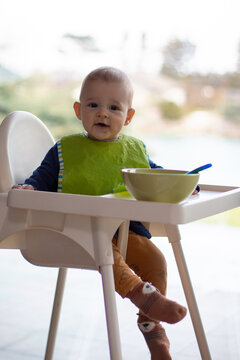 Little Toddler Eating On High Chair, Happy Baby Boy Full Body View, Learning To Eat