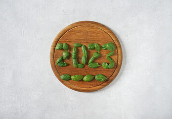 2023 made of spinach leaf on a wooden cutting board, health and healthy lifestyle resolutions Happy New Year