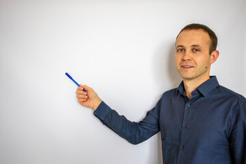 a handsome man stands at the white board and points with a pen. banner for the inscription. mockup.