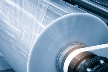 Obraz premium Automatic polyethylene plastic bag production machine with lighting effect. Close-up of the roller of the plastic bag production machine in the light blue scene. product packaging concept