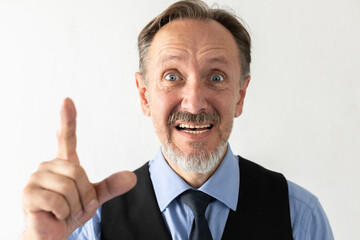 Portrait of excited mature businessman making idea gesture. Senior Caucasian manager wearing formalwear looking at camera, talking and showing forefinger against white background. Idea concept