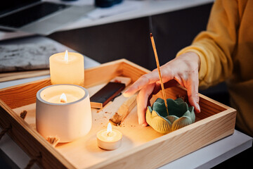 Self care, mental health. Young woman sitting near table with lights candles, Aroma Sticks, enjoy meditation at home. No stress, healthy habit, mindfulness lifestyle, anxiety relief concept