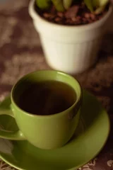 Fotobehang cup of green tea with house plant high angle © Balaj