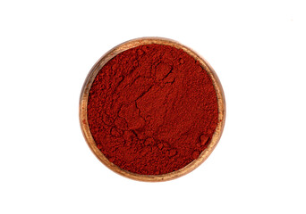 Top view of smoked paprika in wooden bowl over white background.