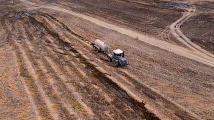 A lone tractor on an autumn plowed field. Dark and terrible technique.