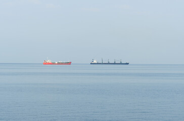 Fototapeta premium A view of cargo ships moving far across the sea.