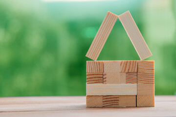 sustainable wooden house concept on green natural background