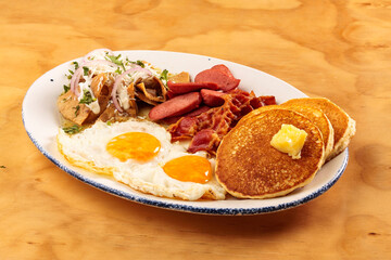 Full American breakfast with eggs, bacon, pancakes, sausage and chilaquiles, food