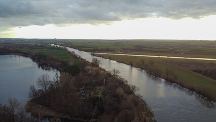 Top view of the river Odra and lake Bolko. Dry trees on the banks. In the background of the house. Poland, Opole