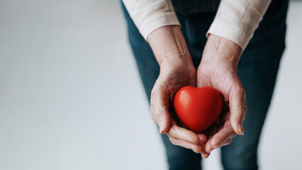 cropped image of a red heart in the hands of a woman.