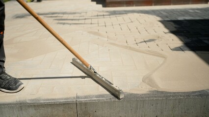 Close-up of sand on a new pavement for grouting between paving slabs. Paving slabs. Sealing seams...