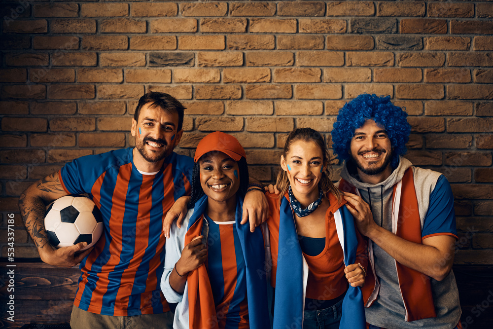 Wall mural Group of happy football fans during the world cup looking at camera. - Wall murals