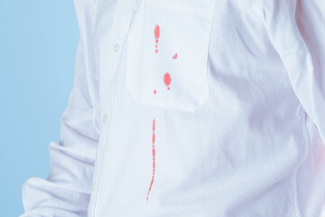 Dirty blood stain on white clothes on a blue background. isolated
