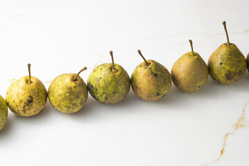 juicy green duchess pears harmoniously lie in the composition on a light white marble background
