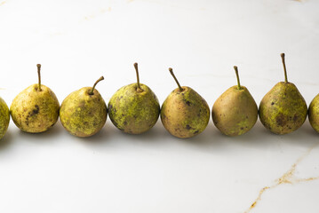 juicy green duchess pears harmoniously lie in the composition on a light white marble background