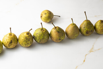 juicy green duchess pears harmoniously lie in the composition on a light white marble background