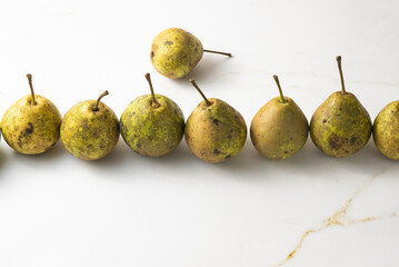 juicy green duchess pears harmoniously lie in the composition on a light white marble background