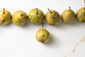 juicy green duchess pears harmoniously lie in the composition on a light white marble background