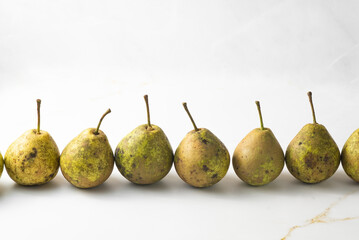 juicy green duchess pears harmoniously lie in the composition on a light white marble background