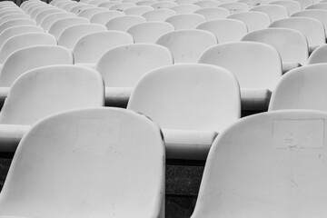 Closeup shot of numerous rows of white plastic chairs