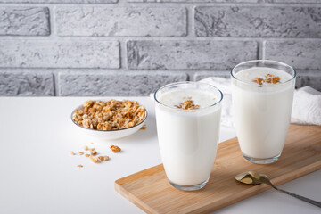 Kefir, buttermilk or yogurt with granola. Yogurt in glass on light background.