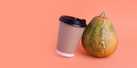 Little pumpkin and white coffee cup near it.Spicy latte or coffee concept,large banner with negative space.