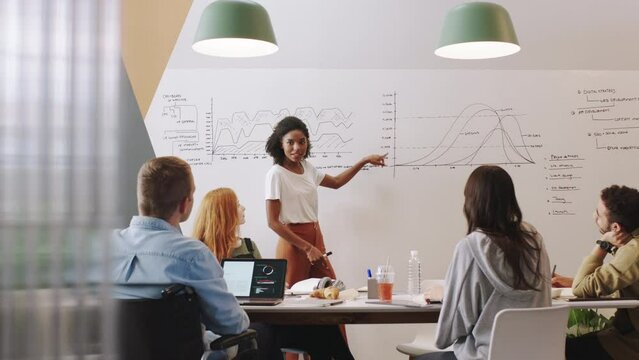 Planning, workshop and training with a creative woman or leader giving a presentation to a team in a strategy seminar. Teamwork, learning and coaching with a design group working on data in a startup