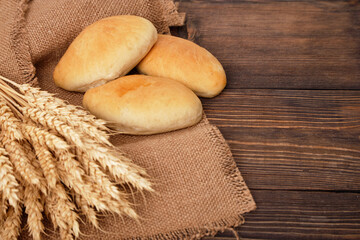 Pies, Bakery products and wheat ears on a brown wooden table