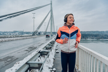 Woman running on the bridge at winter and snow.