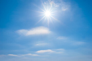 Naklejka na ściany i meble sparkle sun on blue cloudy sky, natural outdoor background