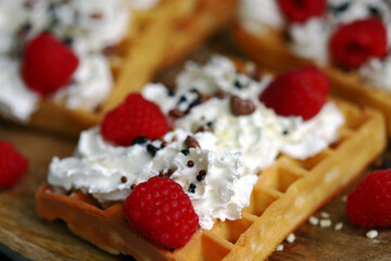 Fresh Viennese waffles with cream and raspberries. Summer dessert with berries.