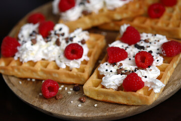 Fresh Viennese waffles with cream and raspberries. Summer dessert with berries.