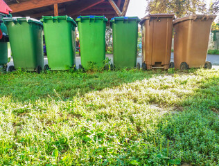 Obraz premium Garbage cans in different colors for waste management, trash recycling bins on the street