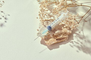 Medicine concept mockup with syringe on a delicate natural beige background and props. Health care,...