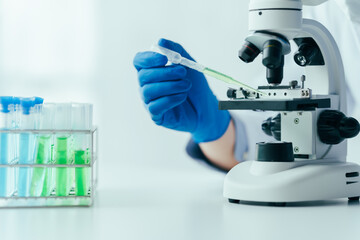 Medical research laboratory asian people male scientist working and analysing liquid biochemicals in laboratory flask.