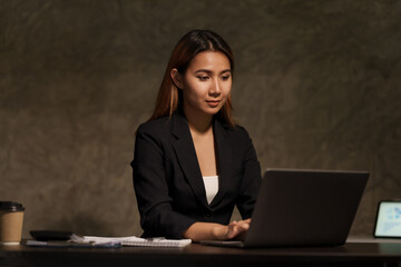 Pretty asian businesswomen working overtime in office at night.
