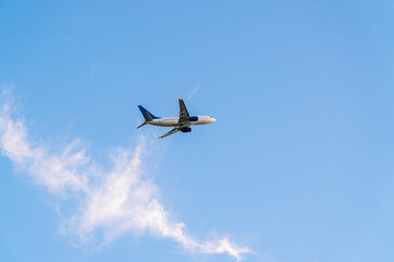 the plane is flying against the blue sky