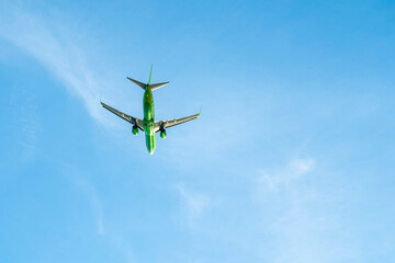 the plane is flying against the blue sky
