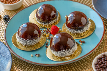 Chocolate cake with raspberry set on a blue plate and chocolate decor on a beige table on a light background.Berry dessert. airy cake souffle.Appetizing cupcakes and pastries.