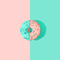 Pink and tiffany green glazed donut on pink and tiffany green pastel background. Flat lay. Creative...