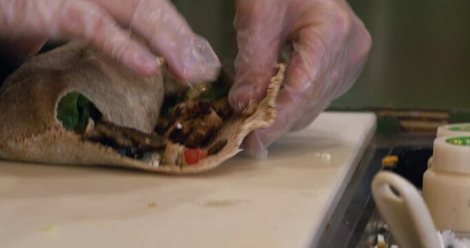 Close-up shot of chef making a burrito at a restaurant.