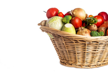 Assorted organic vegetables and fruits in wicker basket isolated on white background. Space for...