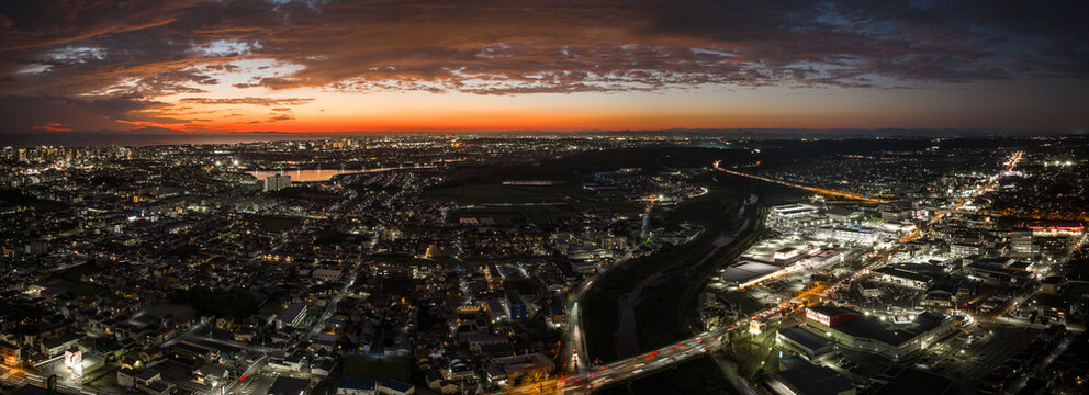 Panoramic Aerial View Of Sunset Over Lights From City Grid